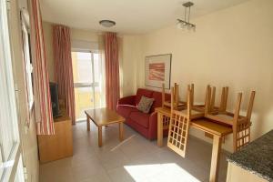 ein Wohnzimmer mit einem roten Sofa und einem Tisch in der Unterkunft Atico con Jacuzzi Las Marinas Vera in Vera