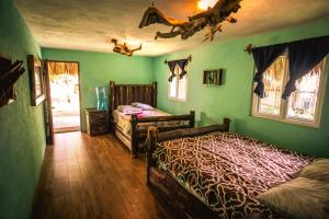 um quarto com 2 camas num quarto com paredes verdes em The Driftwood Surfer Beachfront Hostel / Restaurant / Bar, El Paredon em El Paredón Buena Vista