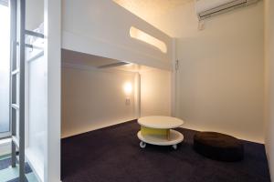 a room with a table and a stool at Granrina Kanazawa - Female only apartment hotel in Kanazawa