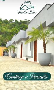 una casa con una palmera delante de ella en Pousada Família Bueno, en Monte Alegre do Sul