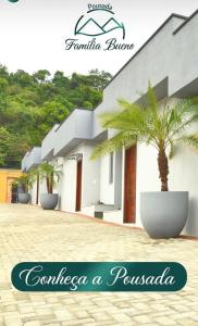 a house with a palm tree in front of it at Pousada Família Bueno in Monte Alegre do Sul