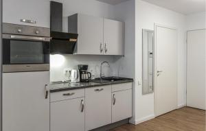 a kitchen with white cabinets and a sink at Amazing Apartment In Hilden With Kitchen in Hilden