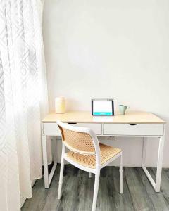 a desk with a laptop on top of it with a chair at Roemah lily studio in Tanah Rata
