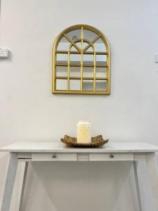 a table with a hat and a mirror on a wall at Roemah lily studio in Tanah Rata