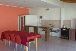 cocina con mesa roja y sillas en una habitación en tiago departamentos modernos en Malargüe