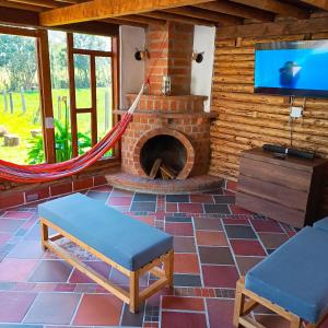 a living room with a brick fireplace and a tv at Chalet del lago Santa Elena in Santa Elena