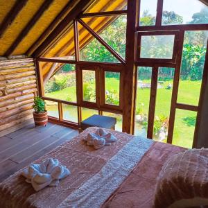 a bed in a room with a large window at Chalet del lago Santa Elena in Santa Elena