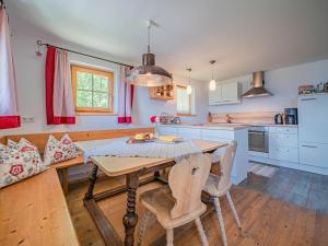 a kitchen with a wooden table and chairs in a room at Rantsch Gebirgsbach in Westendorf