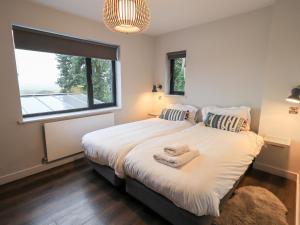 a bedroom with a bed with two pillows and a window at Gillside in Keswick