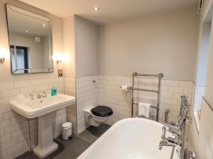 a bathroom with a sink and a toilet and a tub at Gillside in Keswick
