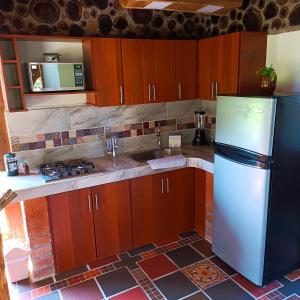 - une cuisine avec des placards en bois et un réfrigérateur dans l'établissement Chalet del lago Santa Elena, à Santa Elena