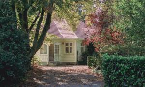 uma pequena casa amarela com um telhado rosa em Hemsworth Estate em Elgin
