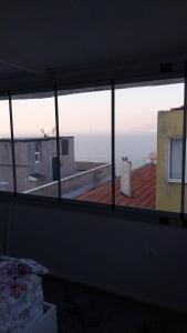 a room with a view of the ocean seen through a window at Güneş in Konak