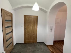 um corredor com uma porta de madeira e um arco em Apartament 3 pokojowy z parkingiem em Zabkowice Ślaskie