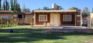 Ein Haus wird gebaut, im Garten liegt ein Gartenschlauch. in der Unterkunft Cabaña Villa Tacú in Zonda