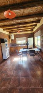 eine Küche und ein Esszimmer mit Tisch und Stühlen in der Unterkunft Cabaña Villa Tacú in Zonda