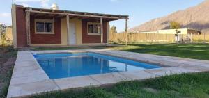 ein Swimmingpool vor einem Haus in der Unterkunft Cabaña Villa Tacú in Zonda