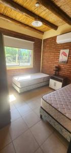 ein Zimmer mit einem Bett und einem Fenster in der Unterkunft Cabaña Villa Tacú in Zonda + 21 Fotos