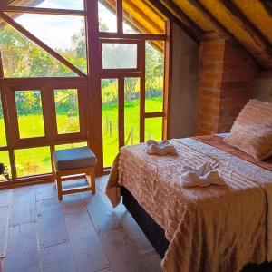 sypialnia z łóżkiem i dużym oknem w obiekcie Chalet del lago Santa Elena w mieście Santa Elena