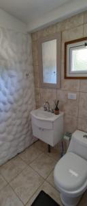 łazienka z toaletą, umywalką i oknem w obiekcie El viejo Boliche Apart w mieście Baggle