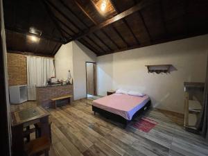 een slaapkamer met een bed in het midden van een kamer bij Casa 4 Estações in Lima Duarte