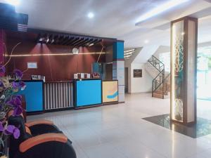 a lobby with a reception desk and a staircase at City Inn Antang in Palangkaraya