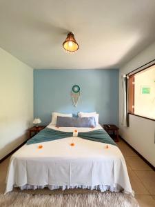 a bedroom with a large bed with orange candles on it at Chez Max Pousada in Morro de São Paulo