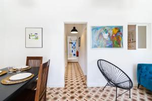 a dining room with a table and chairs and a painting at Casa Levante in Sagres