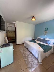 a bedroom with two beds and a television in it at Chez Max Pousada in Morro de São Paulo