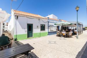 a group of people sitting at tables outside a building at Casa Levante in Sagres