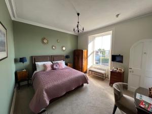 um quarto com uma cama grande e uma janela em Merlindale em Crieff