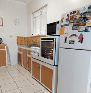 a kitchen with a refrigerator and a microwave at Capon Cottage in Broken Hill