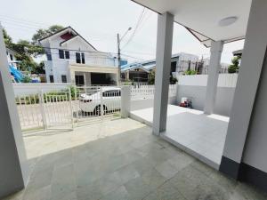 a view from the inside of a house with a white fence at Mara's holiday house in Pattaya South