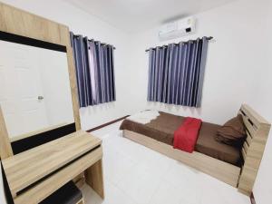 a small bedroom with a bed and a tv at Mara's holiday house in Pattaya South