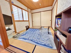 mały pokój z łóżkiem w pokoju w obiekcie 旅籠屋ゆいまーる w mieście Mameda-shimmachi