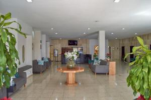 a lobby with couches and a vase of flowers on a table at Hotel del Alba Inn & Suites in Aguascalientes