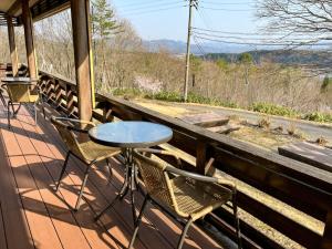 - une table et des chaises sur une terrasse couverte avec vue dans l'établissement 津川温泉 清川高原保養センター, à Aga