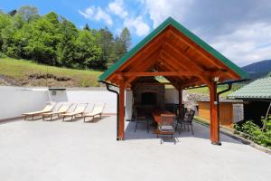 een paviljoen met stoelen en een tafel op een patio bij Holiday house with a parking space Kuzelj, Gorski kotar - 20489 in Delnice