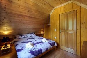 een slaapkamer met een bed in een houten hut bij Holiday house with a parking space Kuzelj, Gorski kotar - 20489 in Delnice