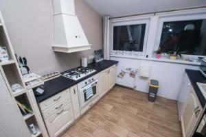 uma cozinha com armários brancos e um forno com placa de fogão em Apartments for families with children Jakovci Netreticki, Karlovac - 20495 em Netretić