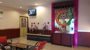 una sala de espera con mesa, sillas y espejo en City Inn Antang, en Palangkaraya