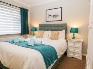 a bedroom with a bed with a blue blanket on it at Kempton in Bowness-on-Windermere