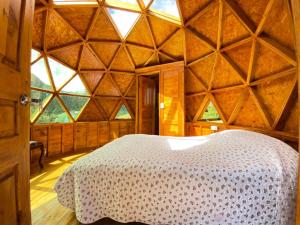 1 dormitorio con 1 cama en una habitación con ventana grande en Colombia Mountain Tours Glamping and Cabanas, en Choachí