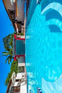 a large swimming pool next to a tall building at Condominio com piscina e ótima localização. in Porto Seguro