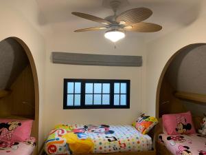 a bedroom with two beds and a ceiling fan at La Chaumière Luxury Domain with 2 Apartments Spa and Pool near Disneyland in Coupvray +183 photos