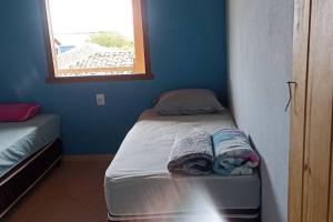 a small room with two beds and a window at casa bela vista in Milho Verde