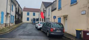 two cars parked in a parking lot next to buildings at Tranquil House 10min from Disneyland Paris in Bussy-Saint-Georges