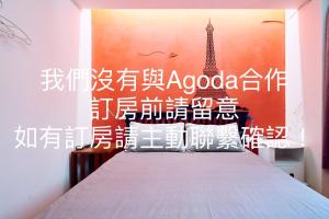 a bedroom with a bed with a poster of the eiffel tower at Corner Inn九份住宿I 小角落民宿I 機車租借I日夜間導覽 in Jiufen