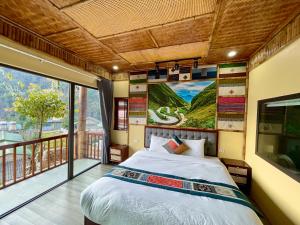 a bedroom with a bed and a large window at DONG VAN CLIFFSIDE HOUSE in Dồng Văn