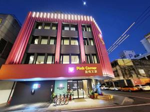 花蓮市にある花蓮品悅文旅Hualien Pink Corner Hotelの自転車が前に停まった建物